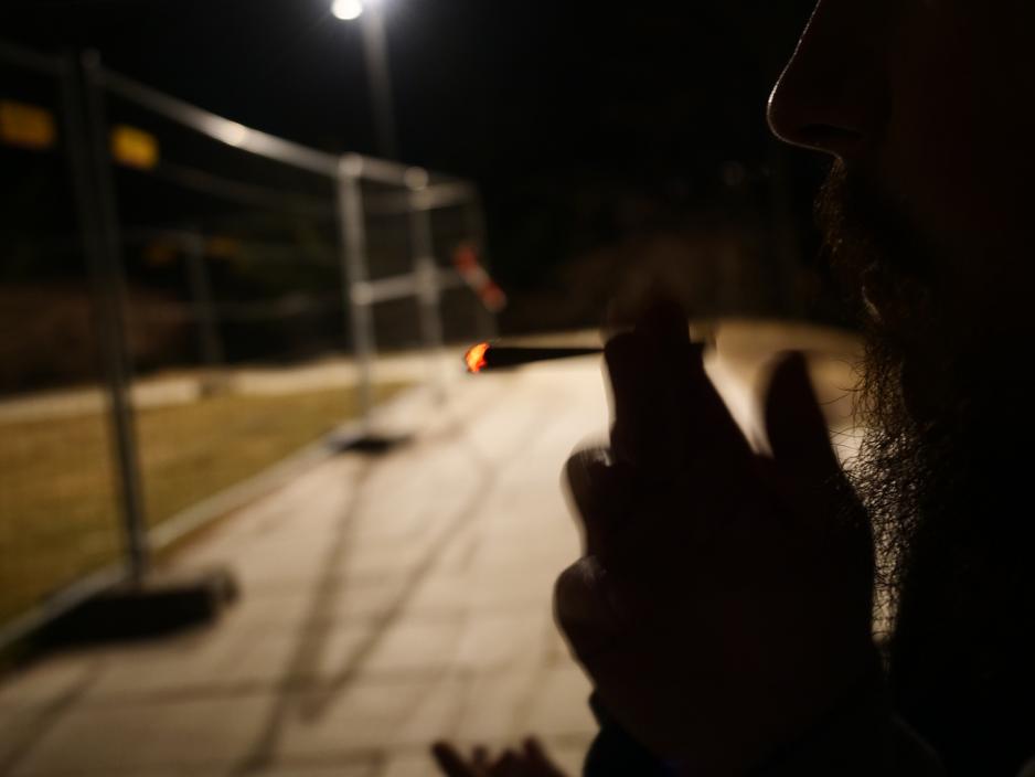 En mann holder en joint i m&oslash;rket