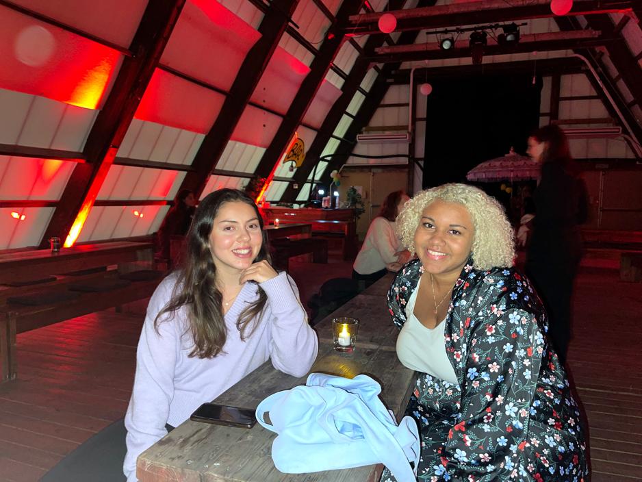 To jenter som sitter inne i et ganske r&oslash;dt rom