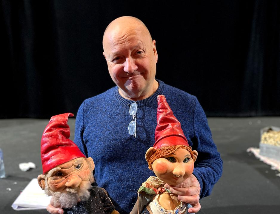 Bildet viser skuespiller Knut Wiulsr&oslash;d som har to nissedukker fra forestillingen p&aring; fanget. Han sitter p&aring; scenekanten. 