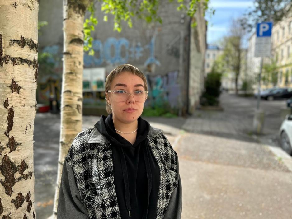 Jente med kort h&aring;r og briller, ser alvorlig ut inn i kamera