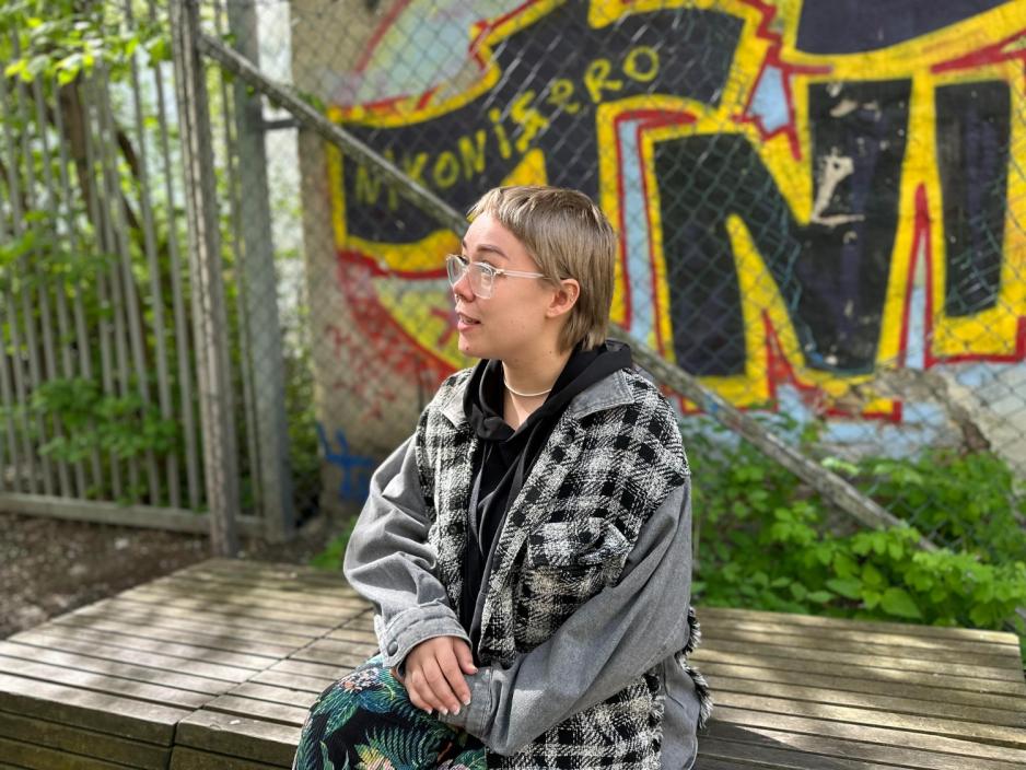 Jente med kort h&aring;r og briller, ser alvorlig ut inn i kamera