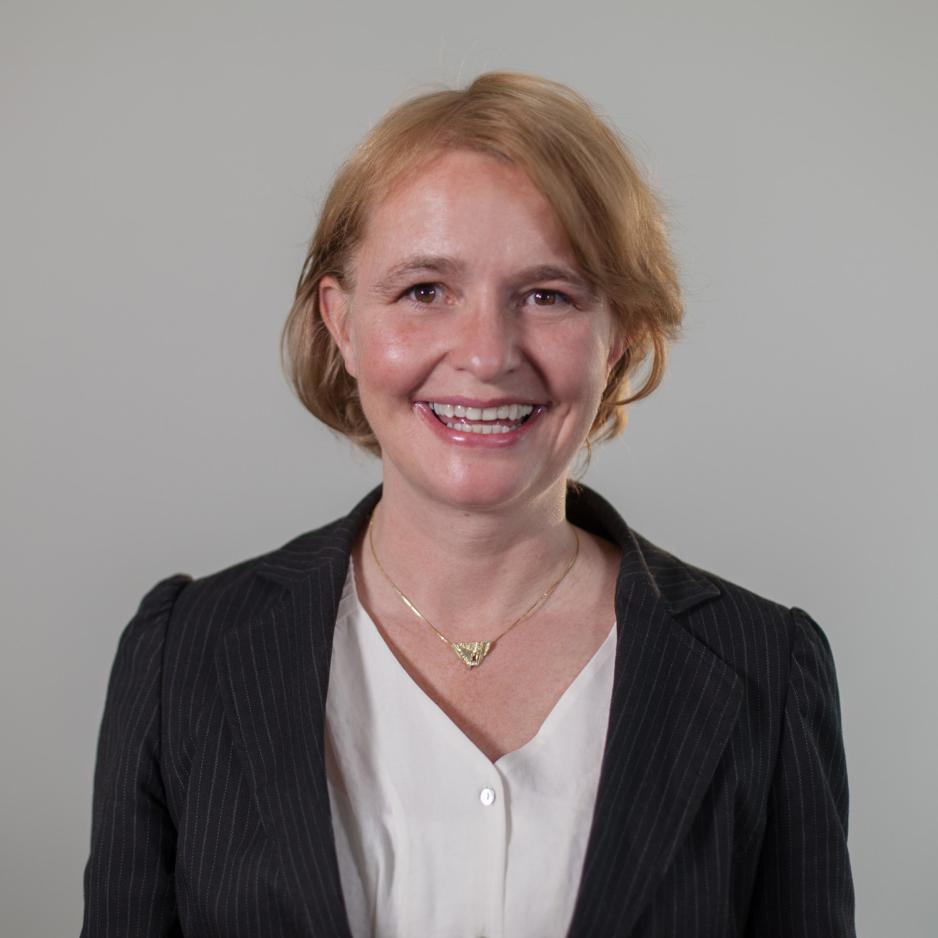 Smilende dame foran gr&aring; bakgrunn