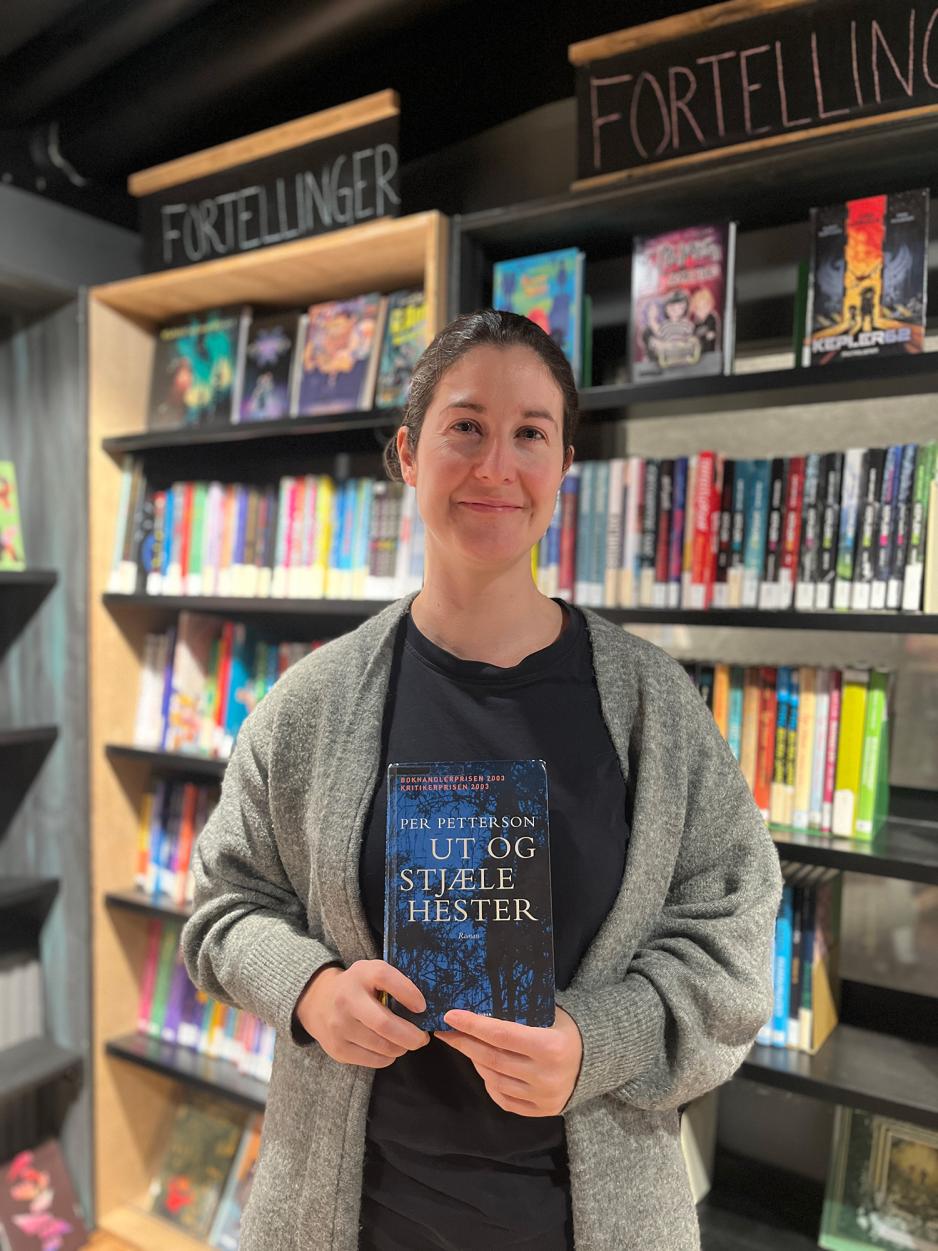 Lisa Nordich foran bokhylle i biblioteket p&aring; T&oslash;yen.