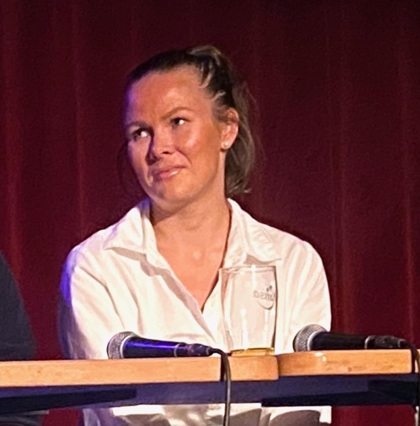 Bildet viser Martine Lunder Brenne. Bakgrunnen er r&oslash;d. Hun smiler, har p&aring; seg en hvitt skjorte og har h&aring;ret i hestehale.