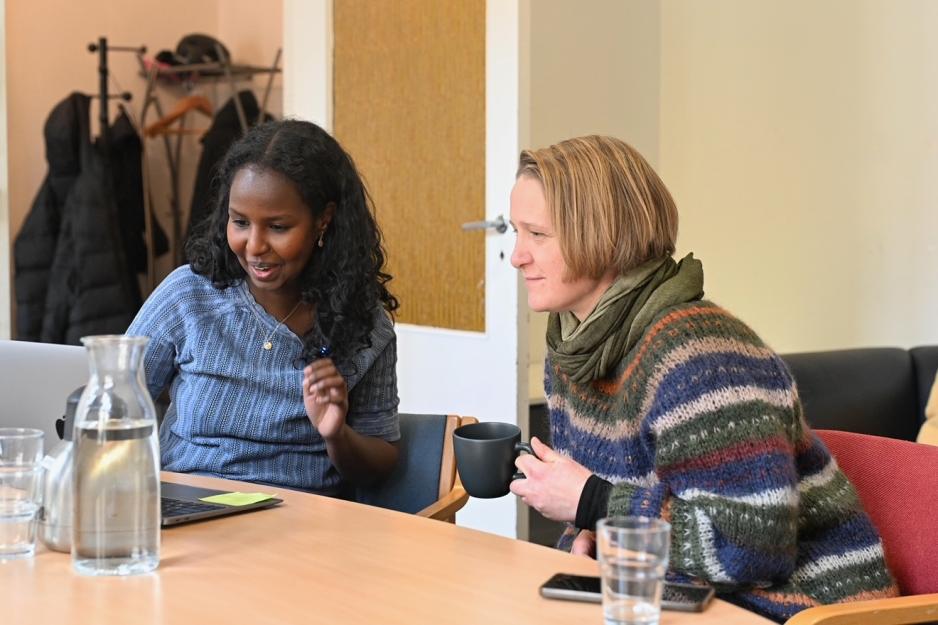 to kvinner som ser p&aring; en laptop og drikker kaffe