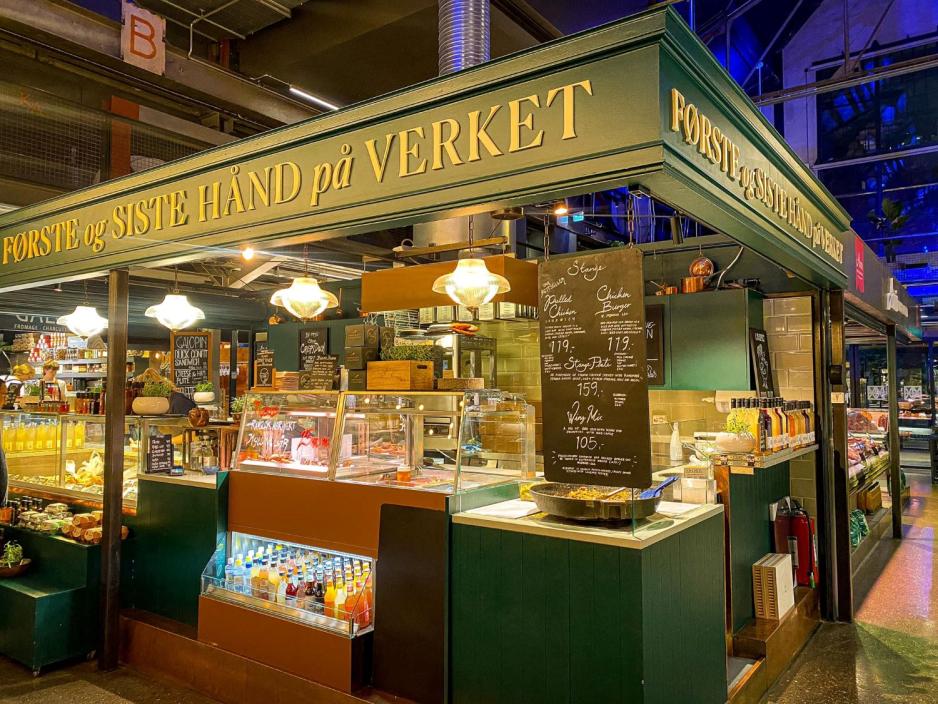 Her ser vi en av restaurantene i mathallen. Den er gr&oslash;nn og heter: ''F&oslash;rste og siste h&aring;nd p&aring; verket''. 