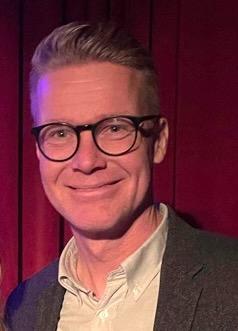 Bildet viser Mats R&oslash;nning. Han smiler til kameraet. I bakgrunnen er det r&oslash;dt.