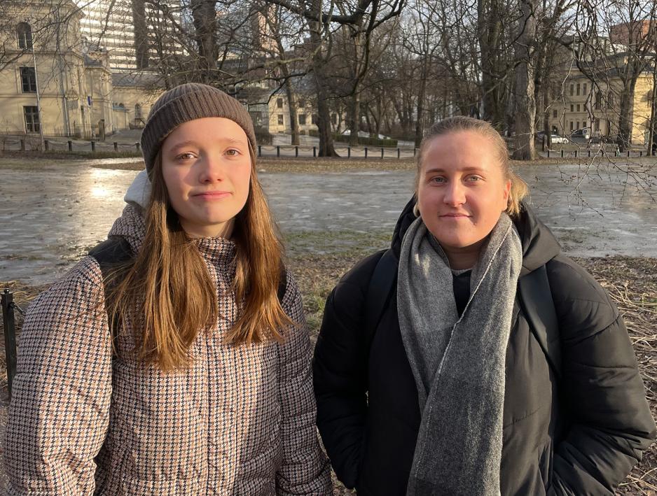 To unge jenter st&aring;r rett opp og ned og ser alvorlig i kameraet. De er i Slottsparken