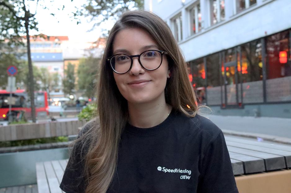 En jente med briller og langt b&oslash;lgete h&aring;r smiler til kameraet. 