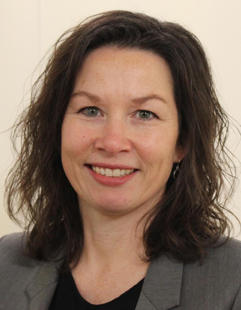 Portrettbilde av Monica Lid fra NRK. Hun har skulderlangt, m&oslash;rkt h&aring;r, og gr&aring; blazer p&aring; seg. Hun smiler inn i kamera.