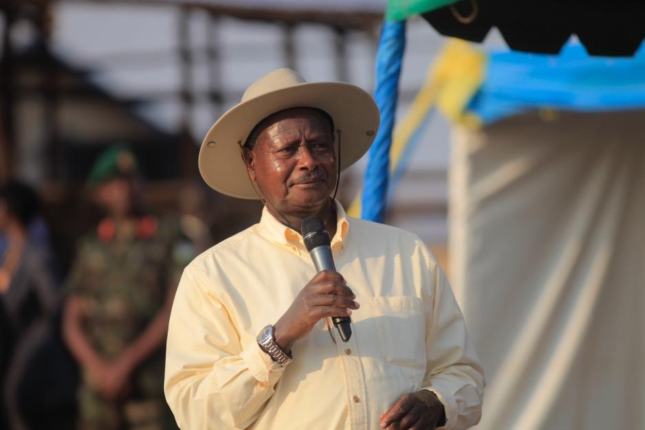 President i Uganda Yoweri Museveni st&aring;r med en mikrofon i h&aring;nden. Han har p&aring; solhatt. 