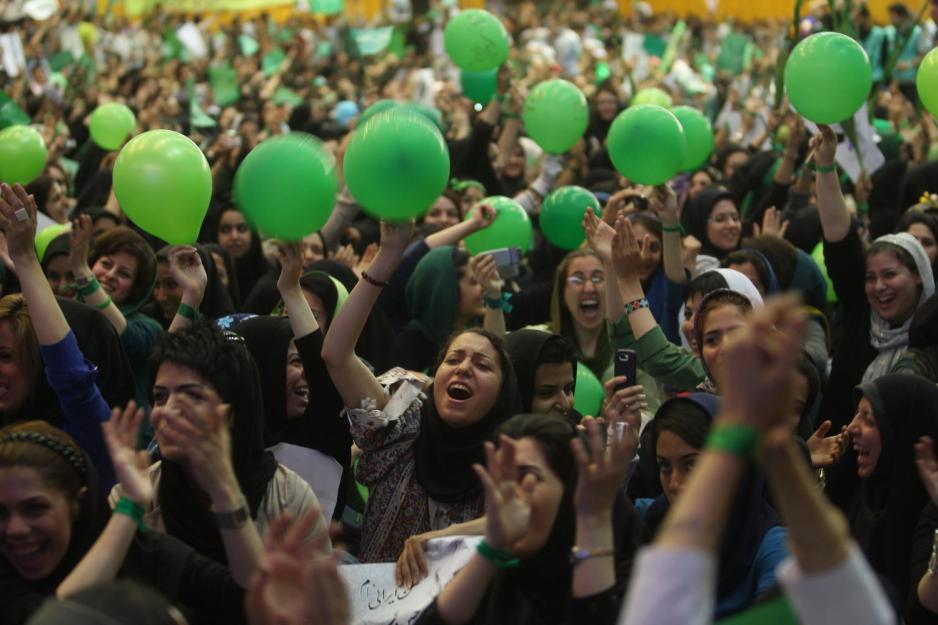 Mengder med mennesker i gr&oslash;nne kl&aelig;r og gr&oslash;nne ballonger. 