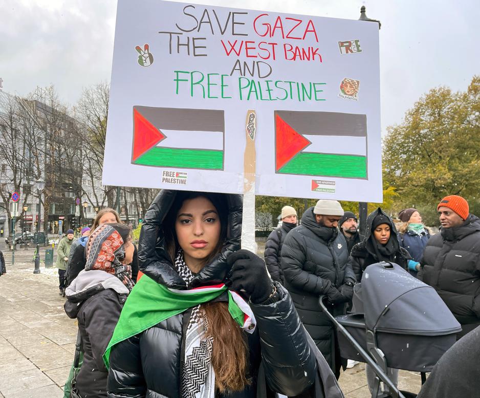 Naya Ikram El Habbach holder et skilt der det st&aring;r "Save Gaza, the west bank, and free Palestine"