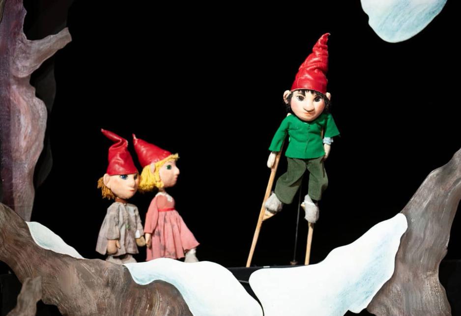 Bildet viser en dukke fra juleforestillingen p&aring; Oslo Nye Trikkestallen som st&aring;r p&aring; stylter. S&oslash;sknene ser p&aring;. 