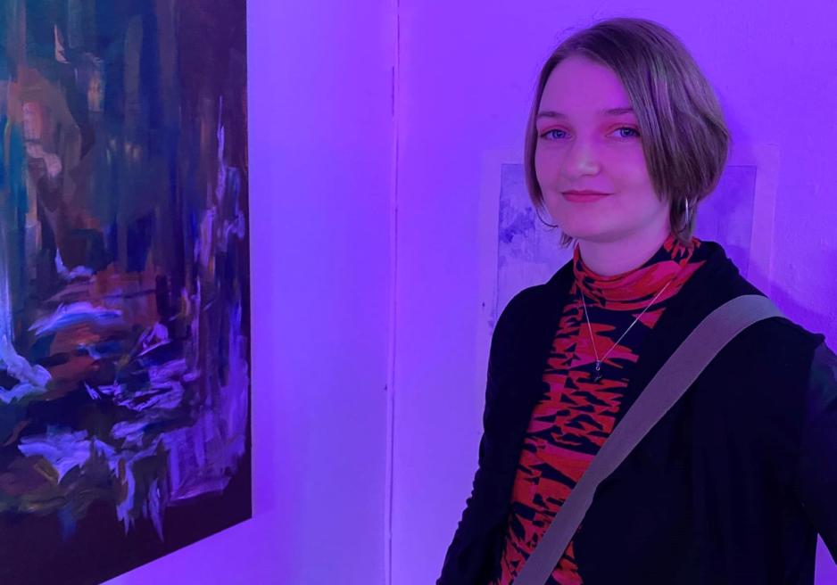 Ei jente med kort h&aring;r foran et vegg. 