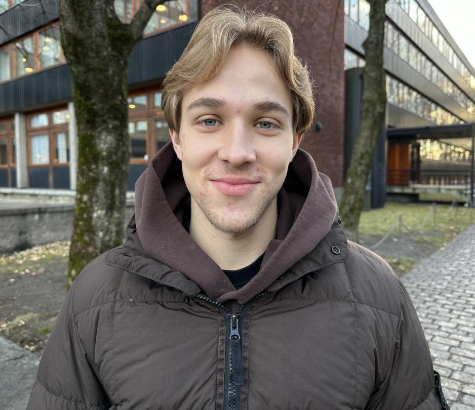 En gutt med m&oslash;rke blondt h&aring;r smiler mot kamera