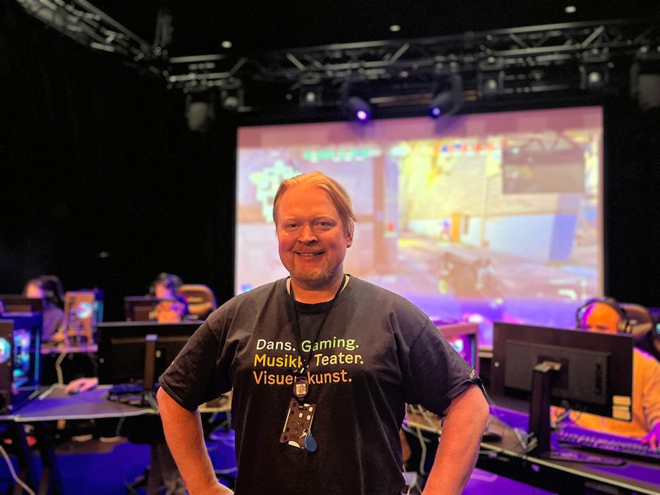 En mann st&aring;r foran som som spiller dataspill. 