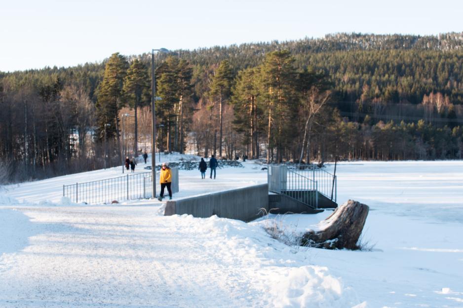 Folk som g&aring;r p&aring; Sognsvann. Kaldt og sn&oslash; ute. Sti til venstre, vannet til h&oslash;yre