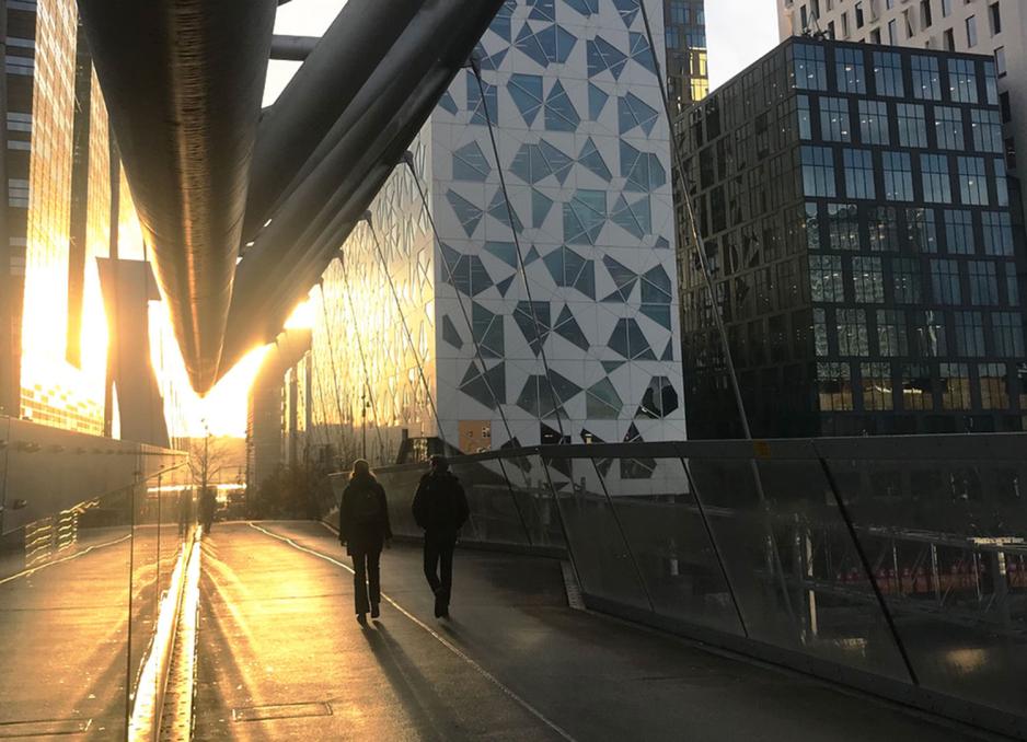 Bilde av et par som g&aring;r sammen over bruen mot Barcode i Oslo.