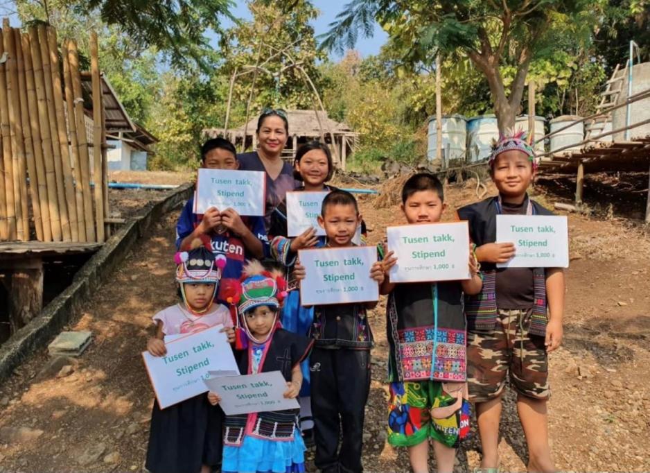 Glade barn i Thailand som holder skilt som viser de har f&aring;tt stipend