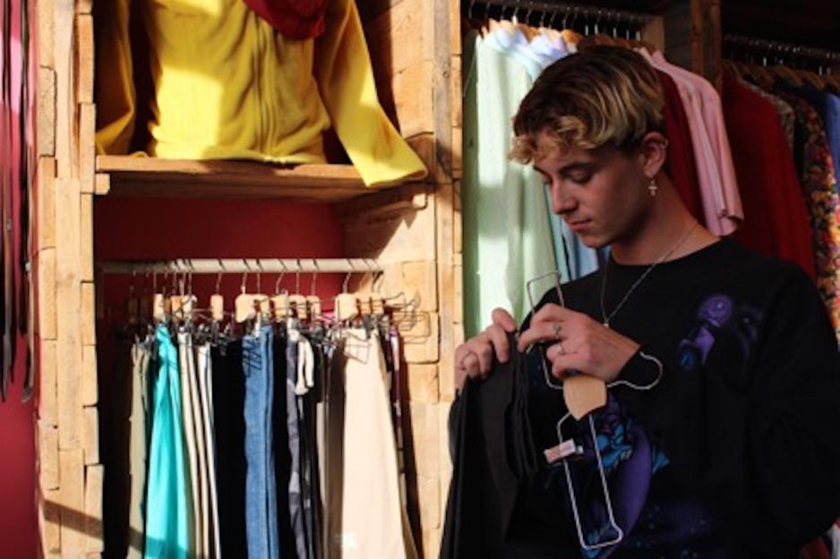 Phillip Eskildsen henger en svart bukse p&aring; en kleshenger 