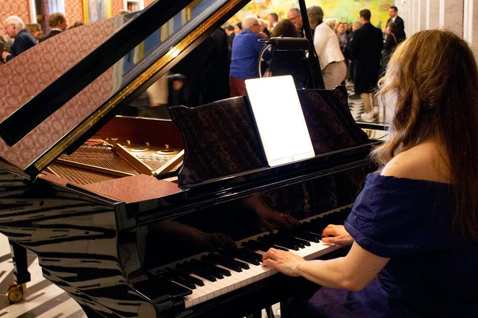 Kvinne som spiller p&aring; piano. 