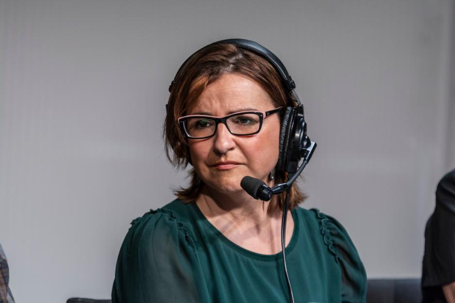 Journalist i gr&oslash;nn genser med hodetelefoner.