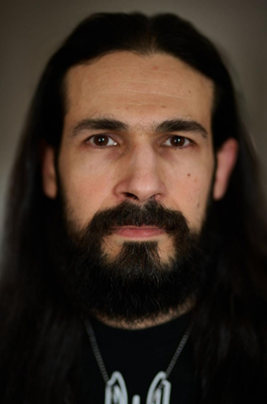 N&aelig;rbilde av en skjeggete mann langt svart h&aring;r.