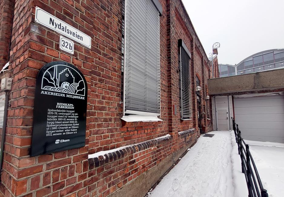 Inngangspartiet p&aring; den gamle redskapsfabrikken i Nydalen, med skilt som forteller om bygget.