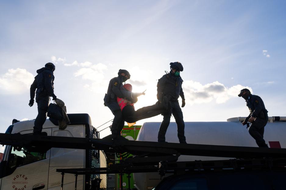 Medlemmer av Beredskapstroppen Delta l&oslash;fter en demonstrant ned p&aring; taket av en panset Toyota Landcruiser.