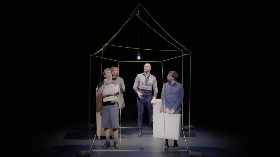 fire belgiske dansere har bygd opp et hus av tr&aring;d. De st&aring;r inne i huset og har hengt opp en lysp&aelig;re de har skrudd p&aring;.