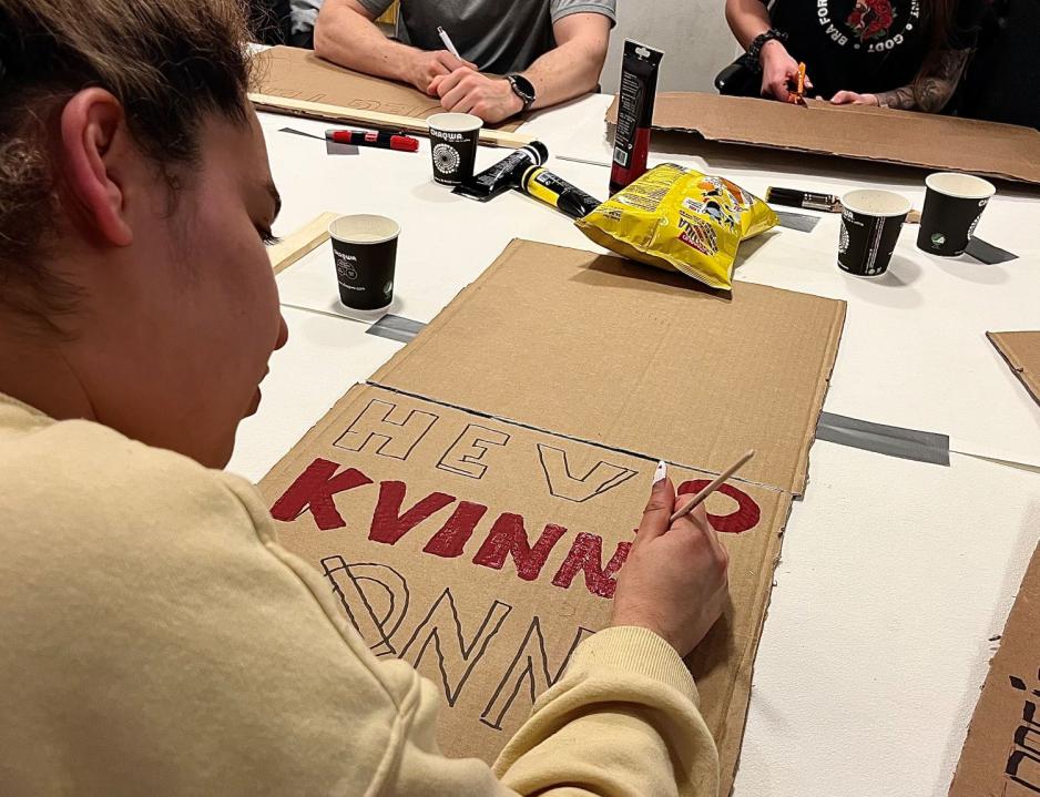 Ayat Saeid maler p&aring; en plakat.