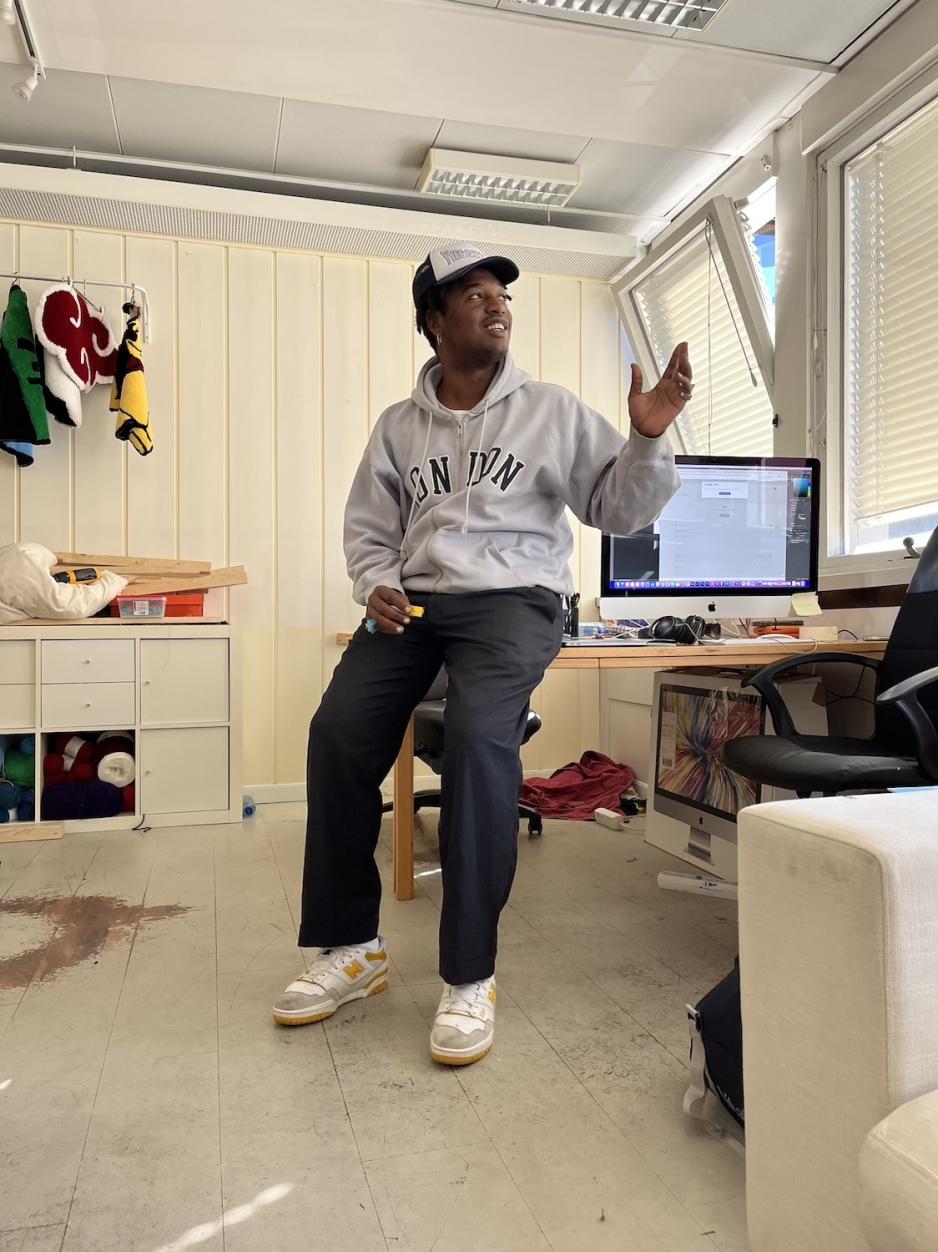 Safari Yves Shabani lener seg p&aring; en hvit pult