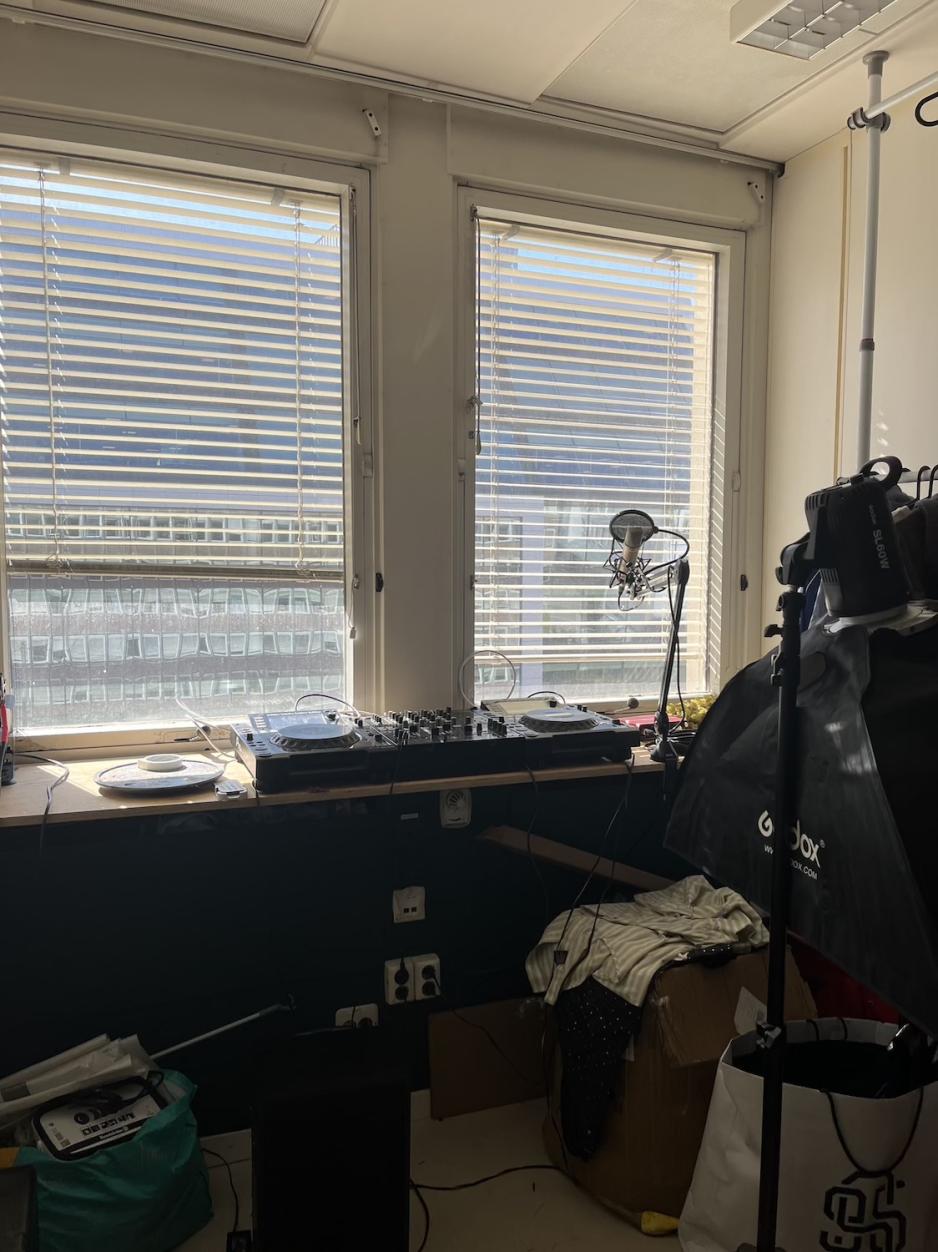 Et miksebord p&aring; en benk under et vindu tildekket av persienner. 