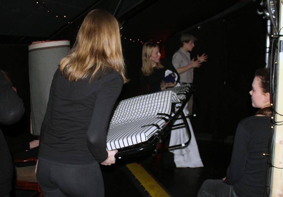 Bilde av scenearbeidere som b&aelig;rer seng