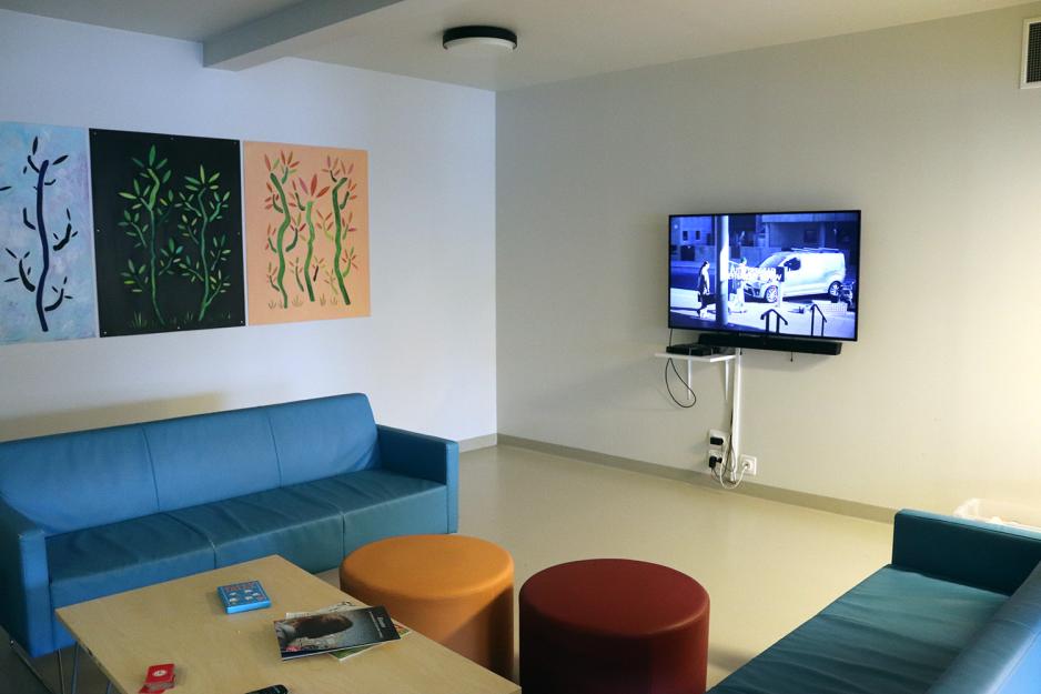 En sofakrok med TV p&aring; veggen.