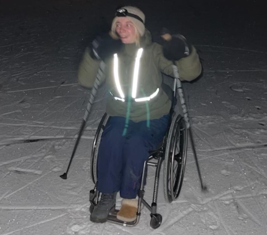 Jente i rullestol p&aring; vinteren, med staver.