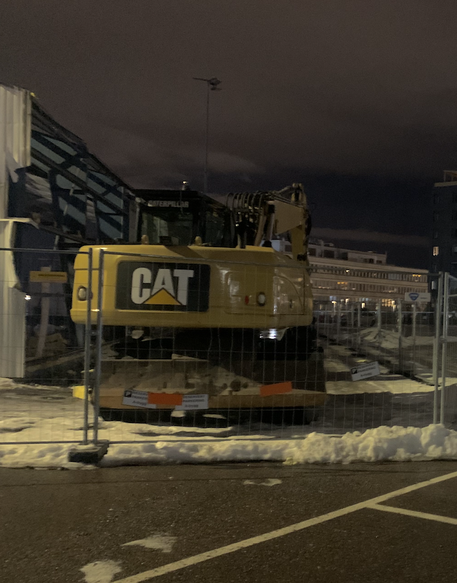 Bilde av omr&aring;det rundt lagerbygningen og en gravemaskin