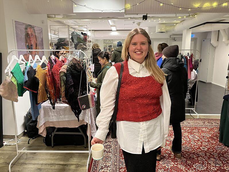 Sophia Johnsson viser stolt frem varene p&aring; &aring;rets julemarked, her foran et stativ med heklede sjal. 