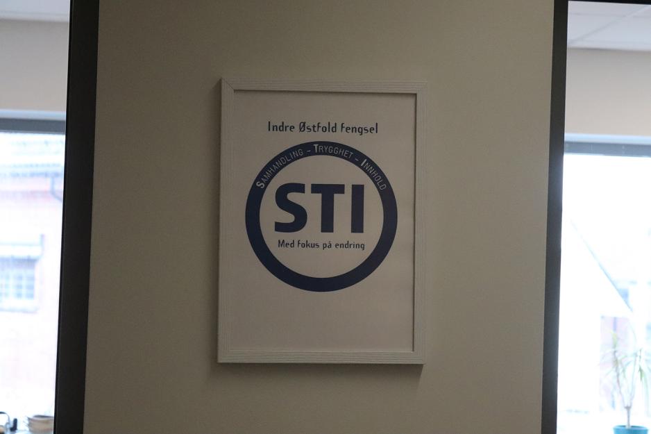 Et bilde p&aring; veggen der det st&aring;r STI inni en sirkel. Rundt sirkelen st&aring;r ordene samhandling, trygghet og innhold.