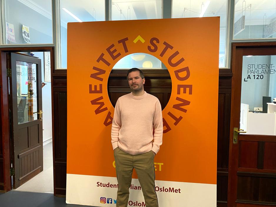 Lederen for Studentparlamentet ved OsloMet st&aring;r foran plakat