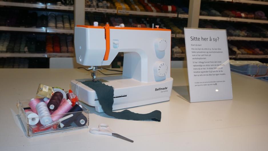 Symaskin med en kurv med tr&aring;druller ved siden av.