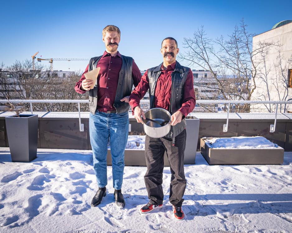 To menn som holder en gryte og er kledd ut som tr&oslash;ndere