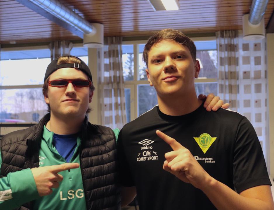 To gutter st&aring;r og lager tegn med hendene