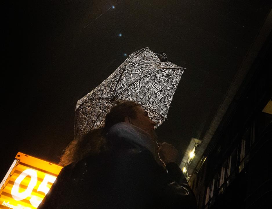 En person ser opp mot himmelen, og ser p&aring; lyskunstverk som maler himmelen. 