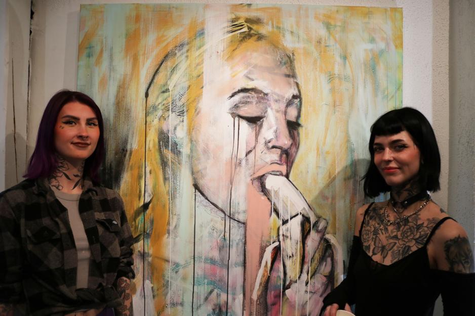 To unge damer som st&aring;r foran favorittbilde p&aring; kunstutstillingen