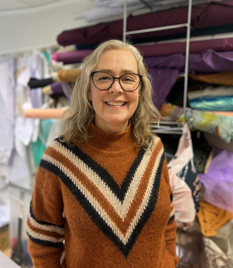 Dame foran vegg med m&oslash;nster og stoff