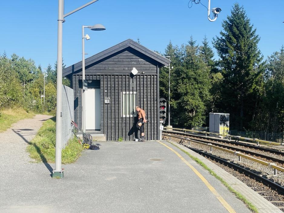 En mann som t&oslash;yer inntil en vegg ved Frognerseteren T-banestasjon. 