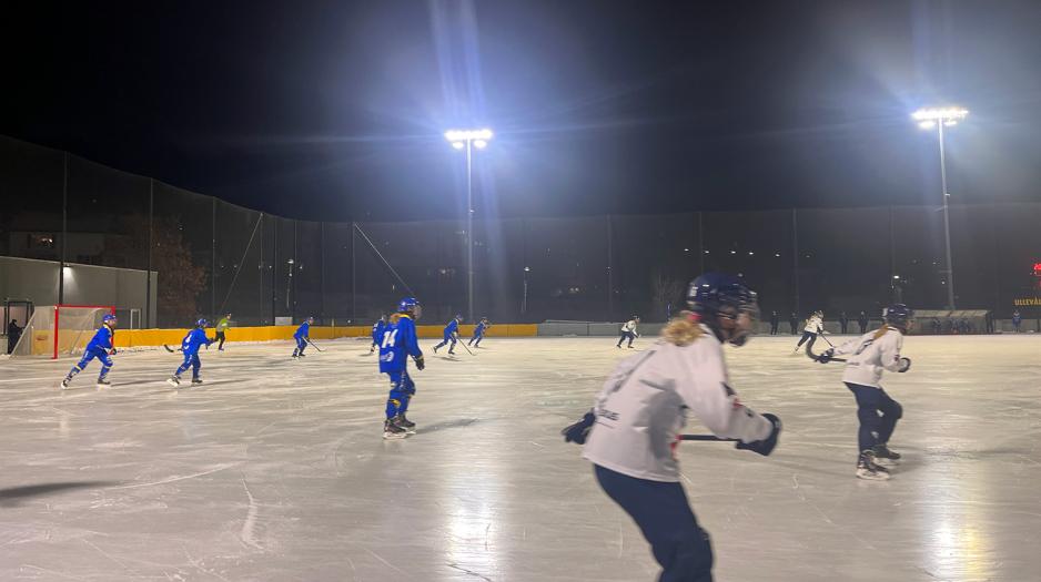 Bandyspillere midt under en kamp. De spiller p&aring; is. 