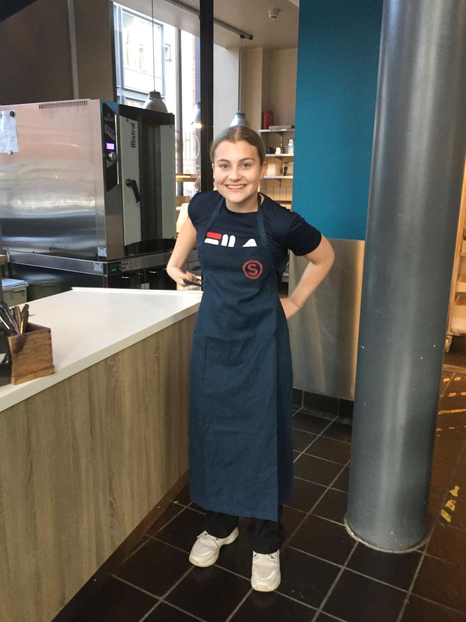 Ungdomsskoleelev med forkle p&aring;, demonstrerer hvordan elevr&aring;det har arbeidet med &aring; skaffe jobber til OD-dagen. 